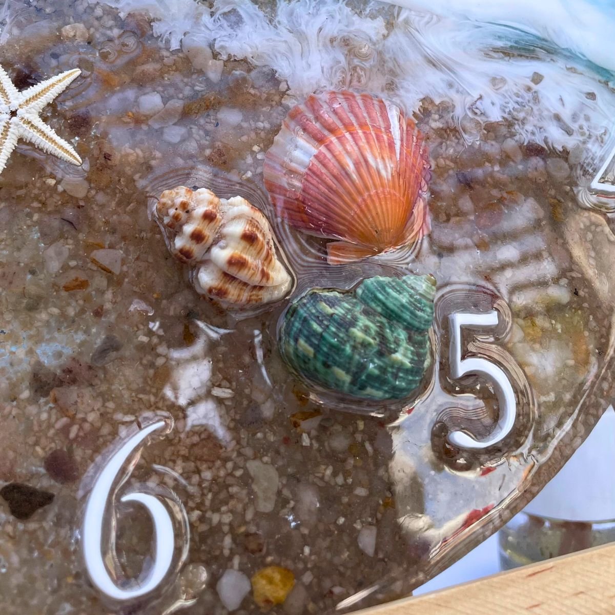 DEtalle reloj decorativo de playa con conchas y efecto océano