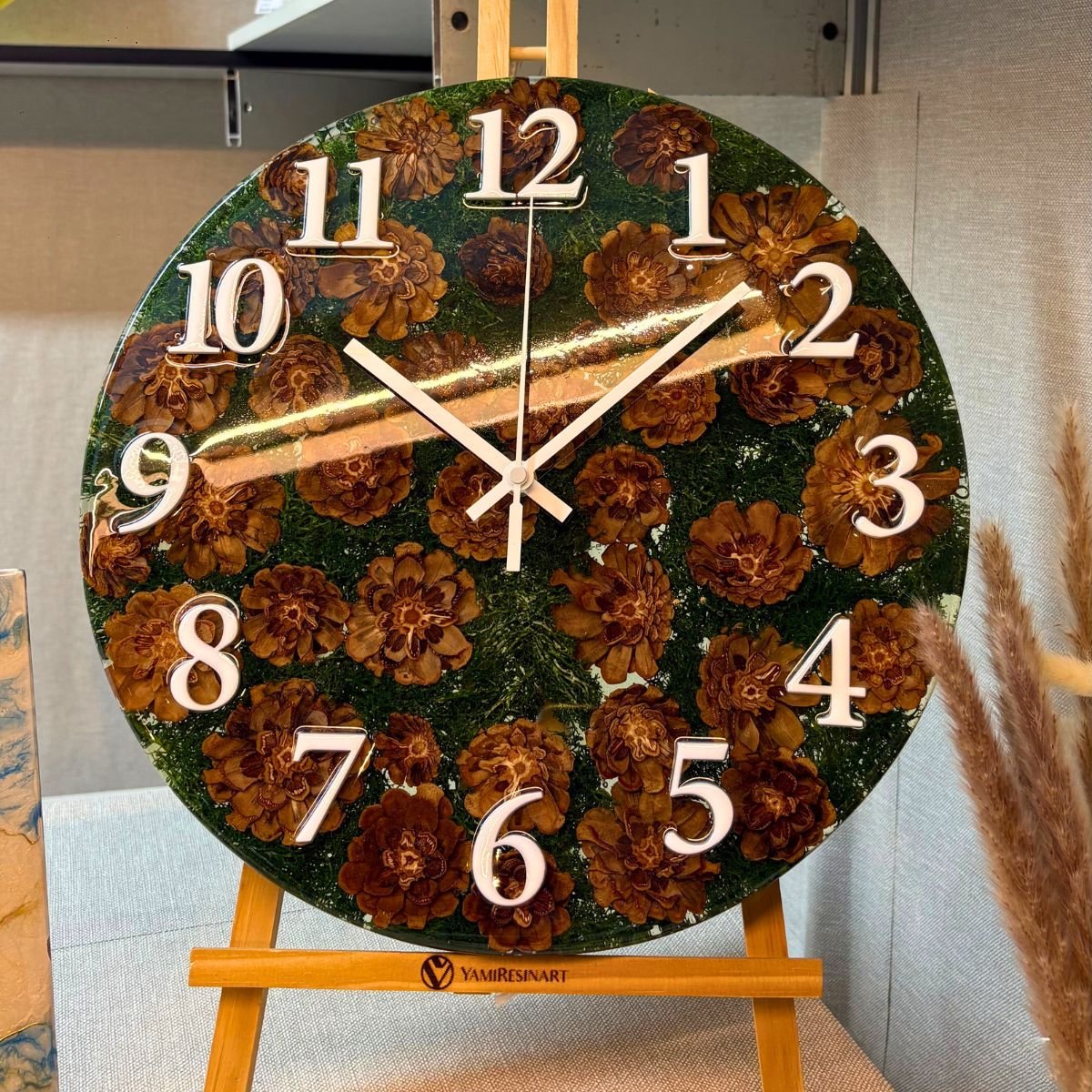 reloj artesanal con piñas naturales y musgo encapsulados en resina