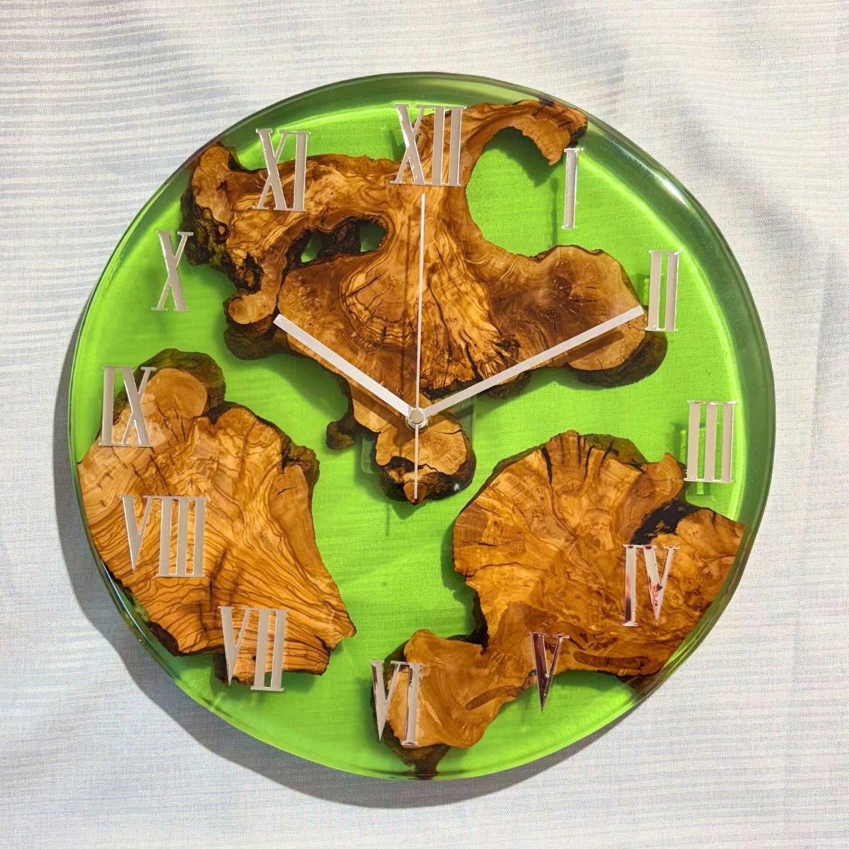reloj artesanal de pared en madera de olivo y resina verde intenso